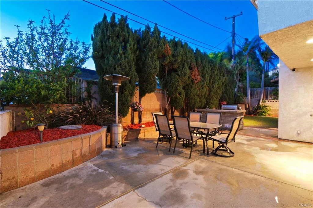 Patio with table, chairs, and plants.