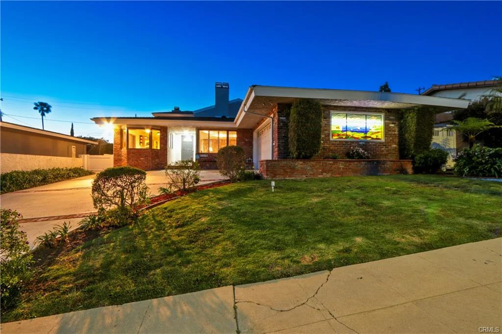 Suburban house with lawn, bushes, window, and garage, California real estate.