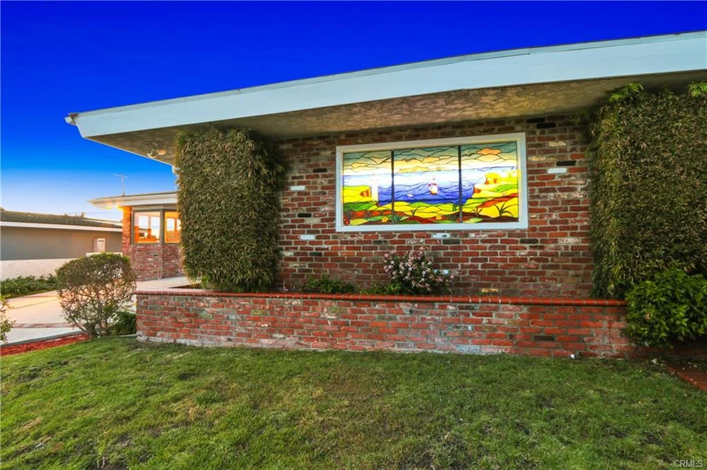 House with stained glass window and plants, California real estate.