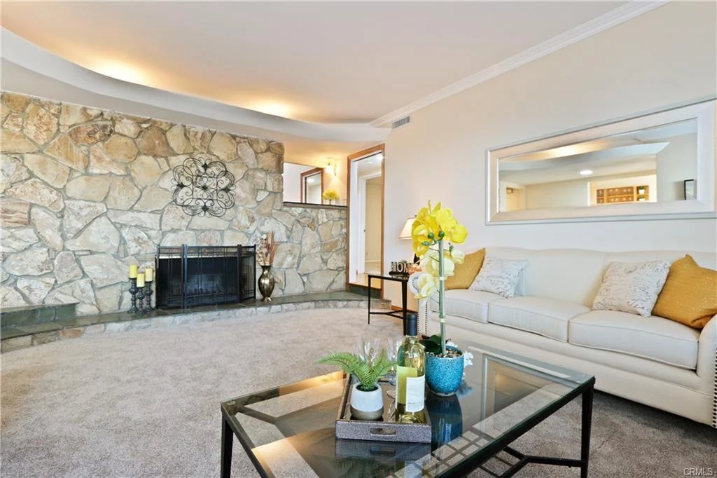 Dining area with round glass table, chairs, and windows.