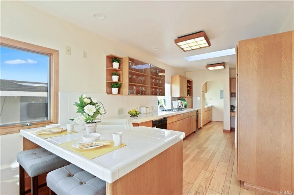 Kitchen with wooden cabinets, large island, and bar seating.