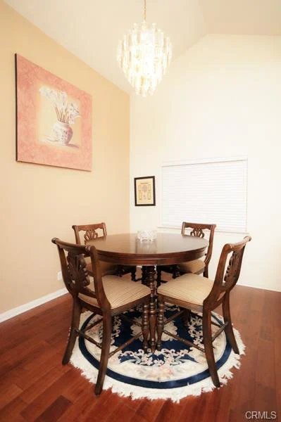 Dining area with a wood table, chairs, and a rug.