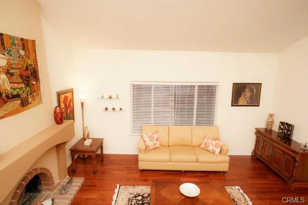 Living room with a wood coffee table, couch, and fireplace.