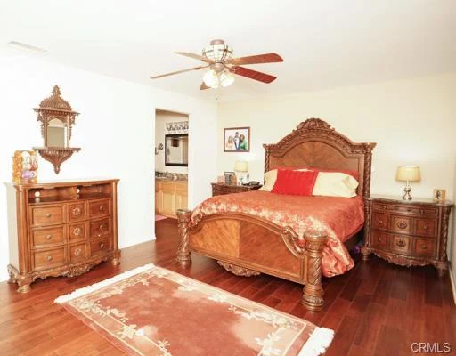 bedroom with a wood bed, two lamps, and a rug.