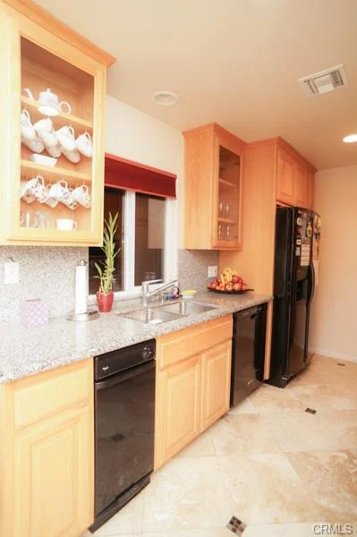 Kitchen with wood cabinets, a sink, and fruit on the counter.