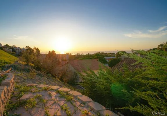 Scenic view with trees, rooftops, and water.