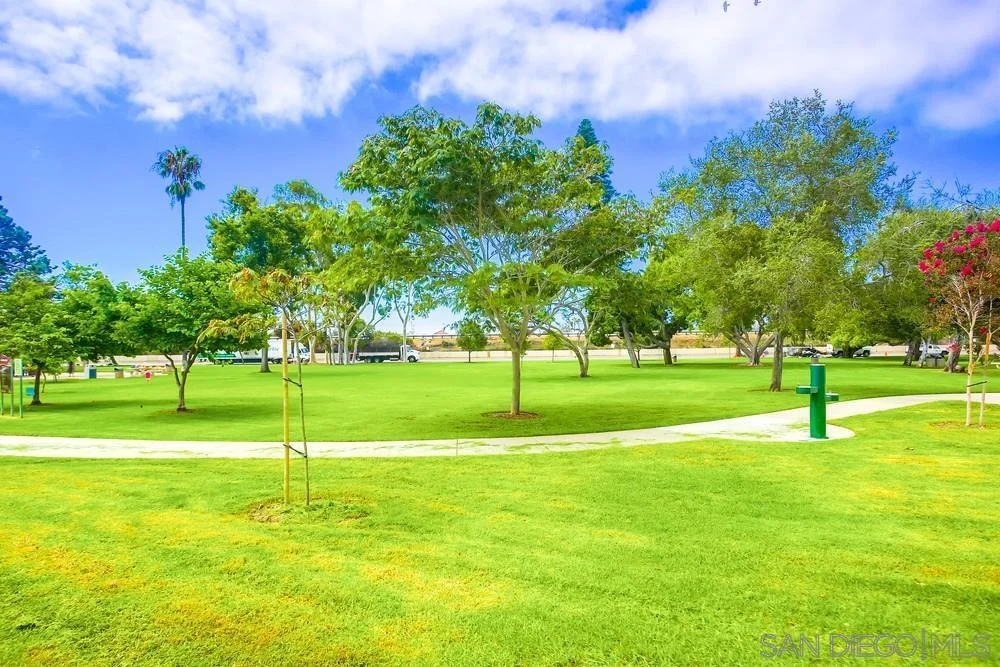 Park with green grass, trees, and pathway.