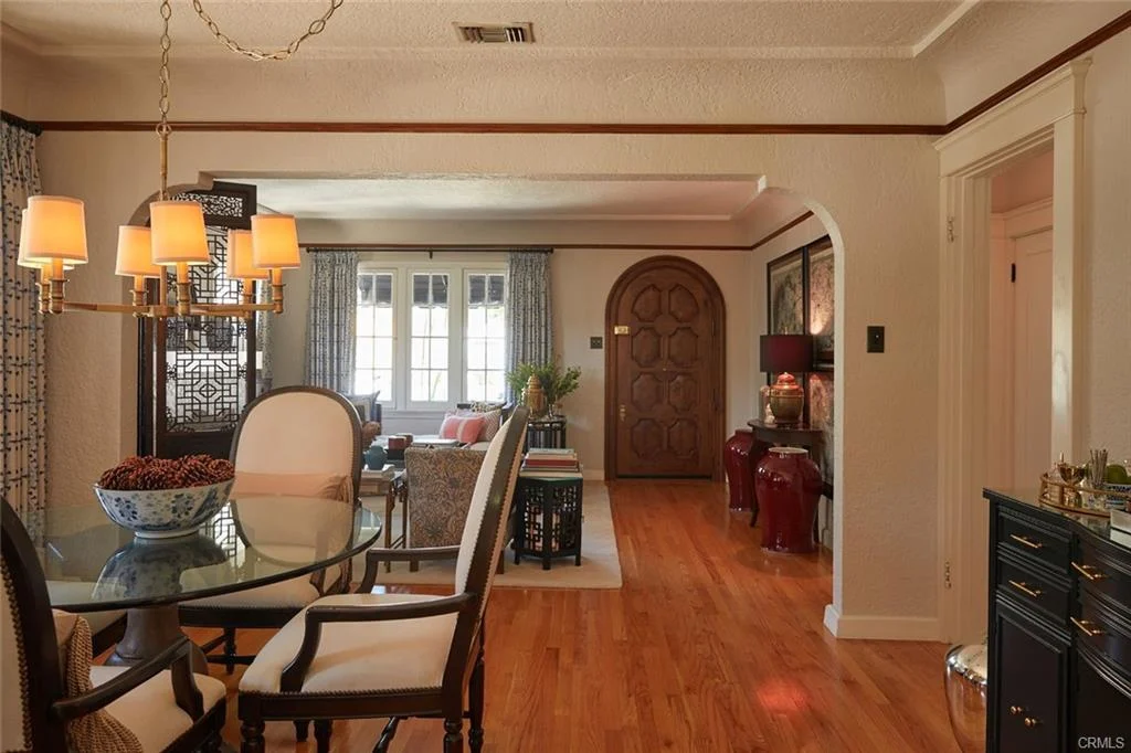 Interior space with dining area, chandelier, and wooden door.