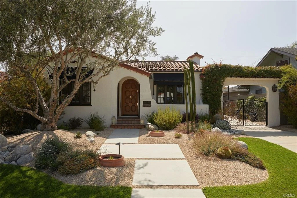 House in California real estate with tiled roof, plants, stones, and front entrance
