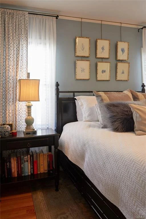 Bedroom with bed, pillows, nightstand with lamp, and framed artwork.