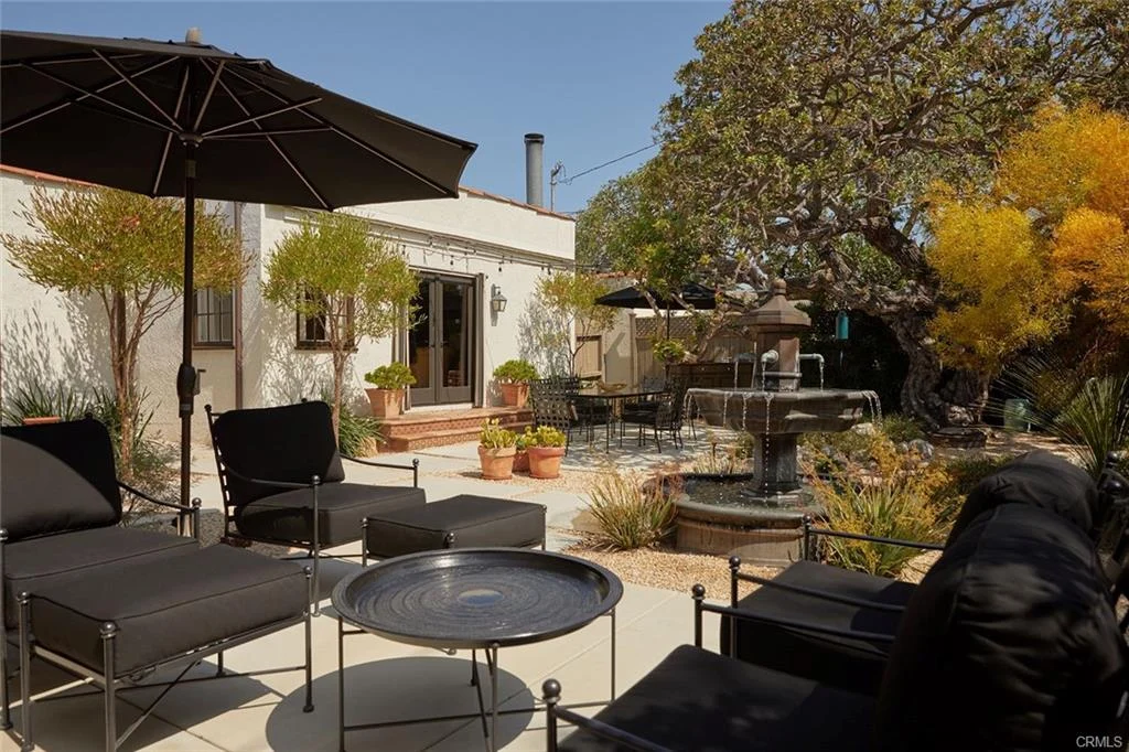 Patio with chairs, tables, fountain, and plants