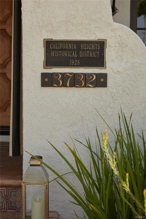 Historic plaque and house number 3732 with lantern and plants