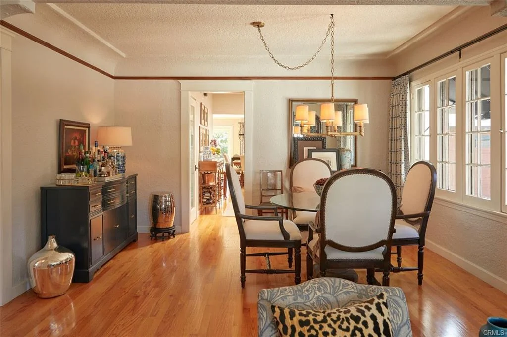 Dining area with table, chairs, sideboard, chandelier, wall art, and wooden floor
