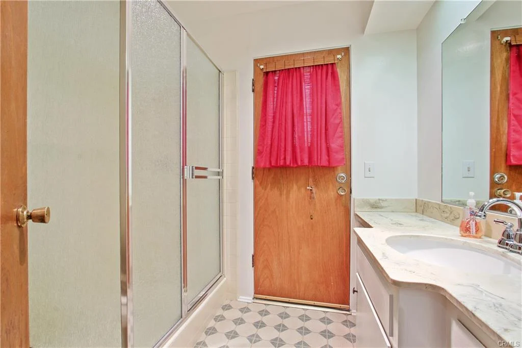 Bathroom with shower, sink, and door.