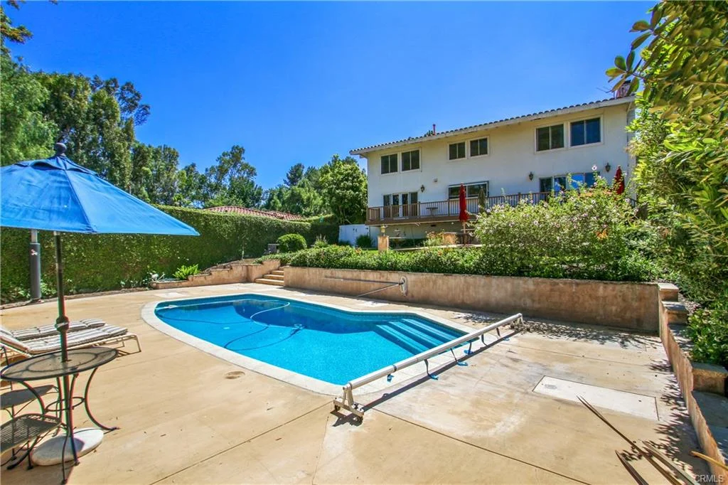 Backyard with swimming pool, patio furniture, plants