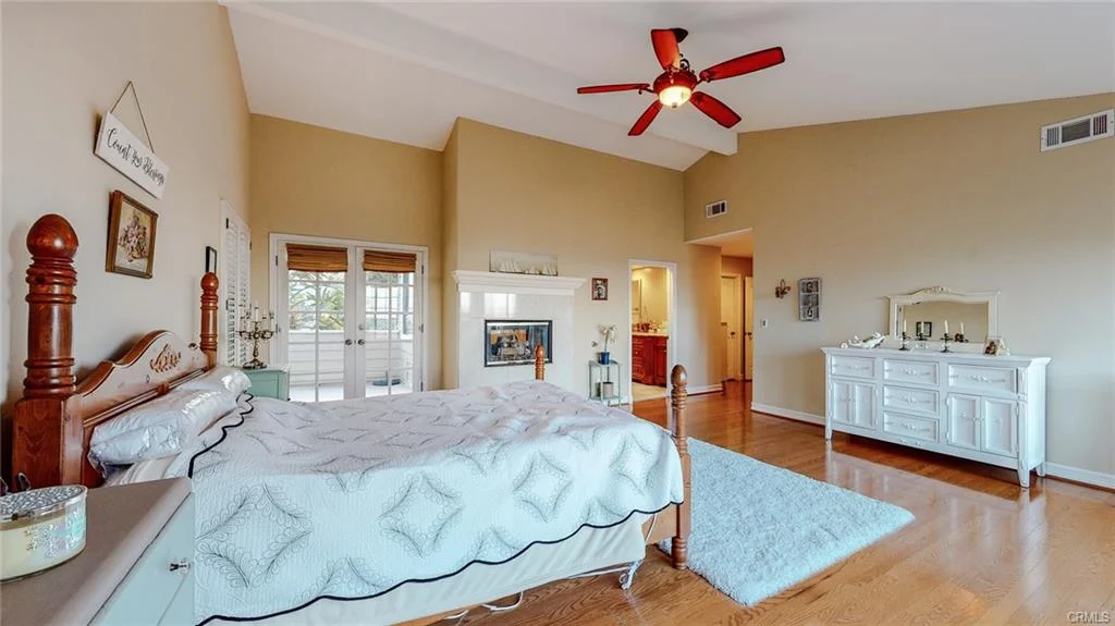 Bedroom with queen bed, ceiling fan, wooden floor, windows, and dresser