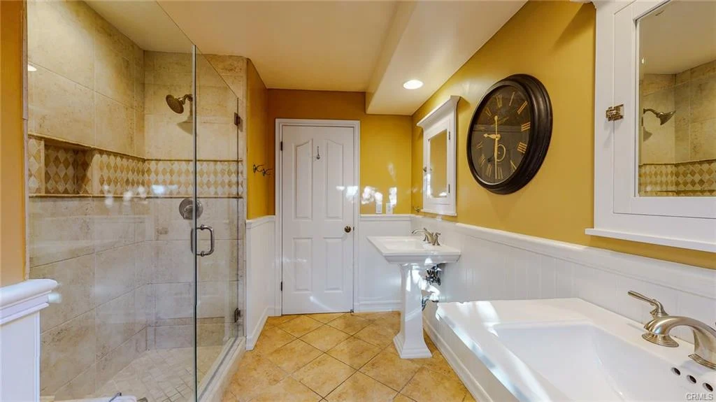 Bathroom with walk-in shower, bathtub, sink, cabinets, and mirrors