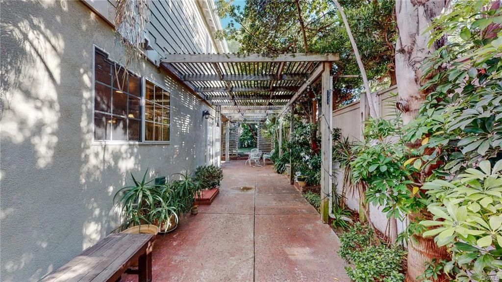 Pathway with pergola, greenery, and benches