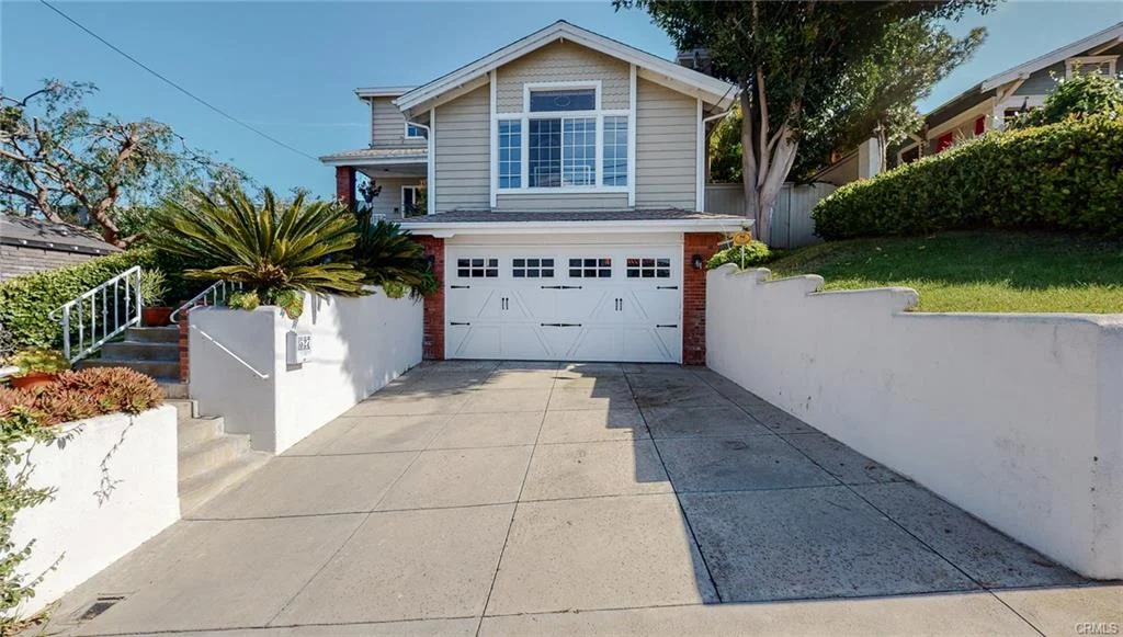 house with large driveway, two-car garage, and landscaped front yard California real estat