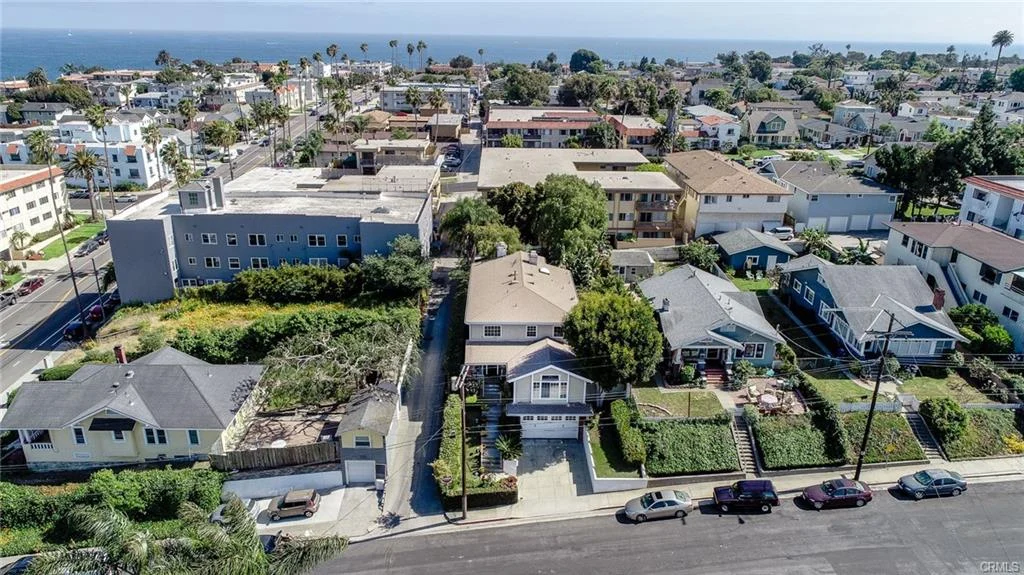 Residential neighborhood with houses, roads, and ocean view