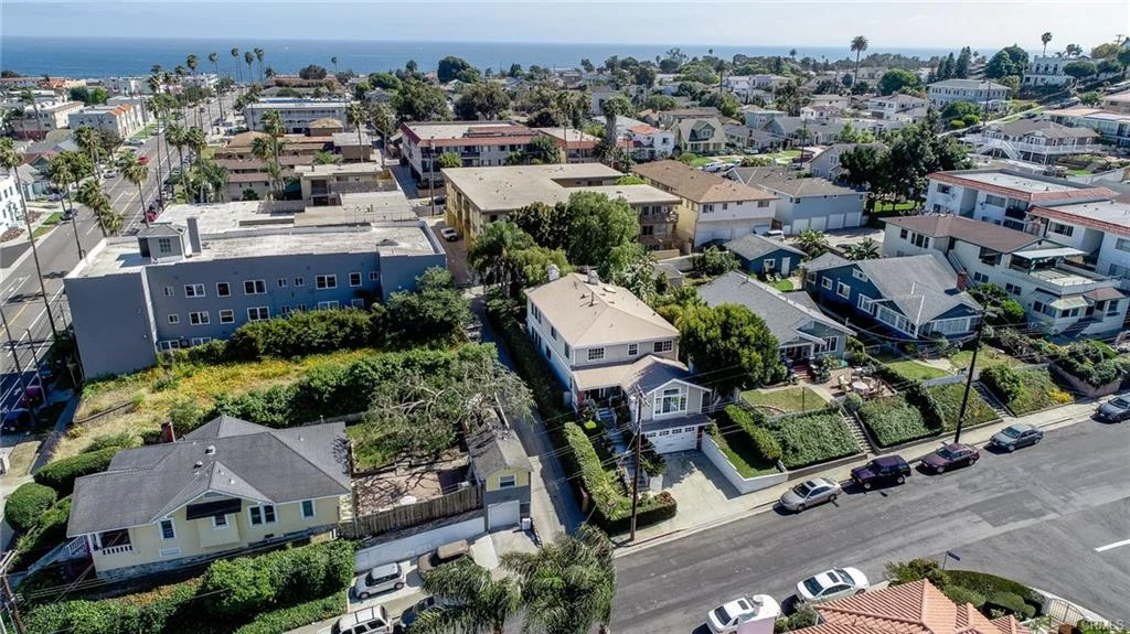 Coastal neighborhood with houses, trees, streets, and ocean view