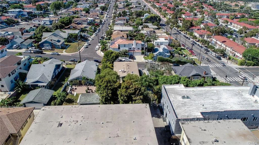 Residential neighborhood with streets, houses, greenery, and ocean nearby
