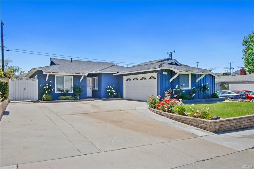 California real estate house with a big yard and flowers.