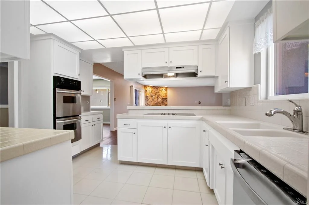 White kitchen with a kitchen island and two ovens.