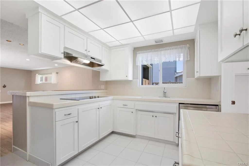 White kitchen with a sink and many cabinets.