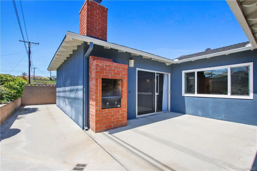 House California real estate with brick chimney, blue walls, and patio with sliding doors