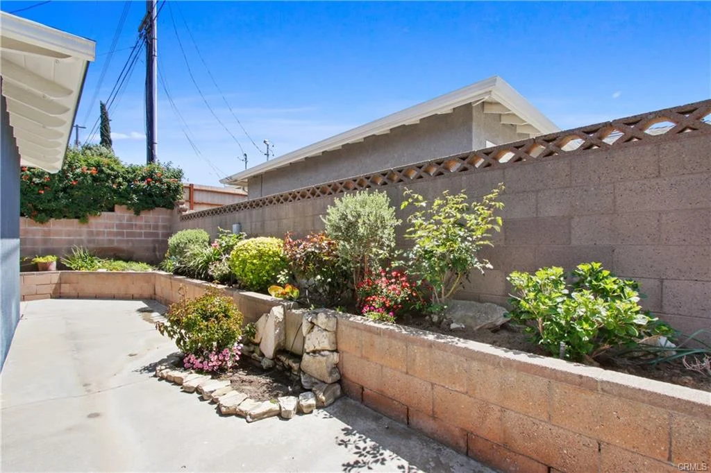 Garden with plants and flowers enclosed by low brick wall
