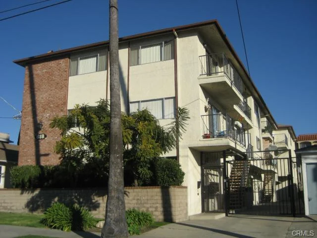 Building with brick, stucco, balconies, and front landscaping