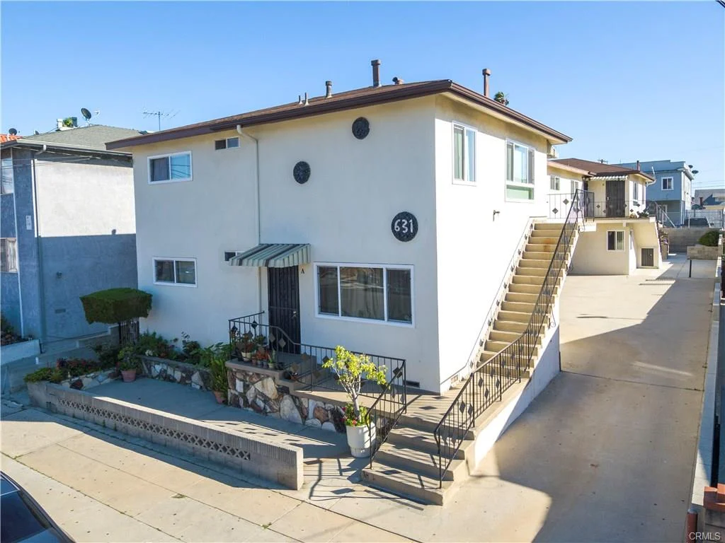 Two-story house California real estate with number 631, garden, stairs, and parked cars