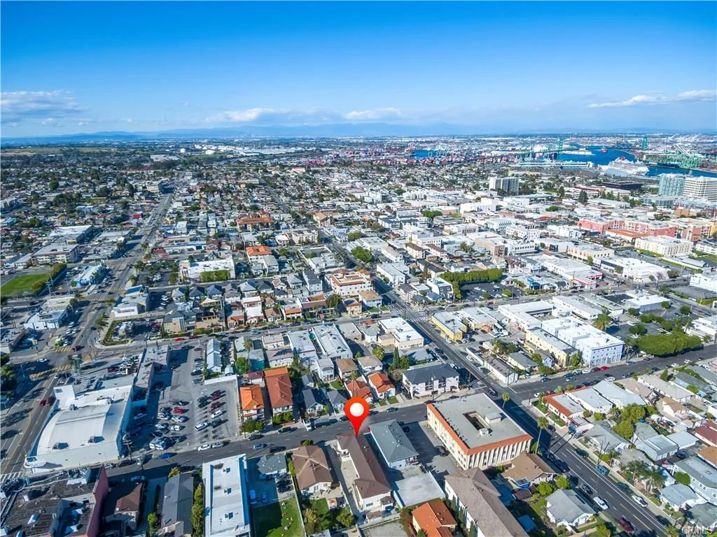 Aerial view of city with buildings, roads, trees, and location marker