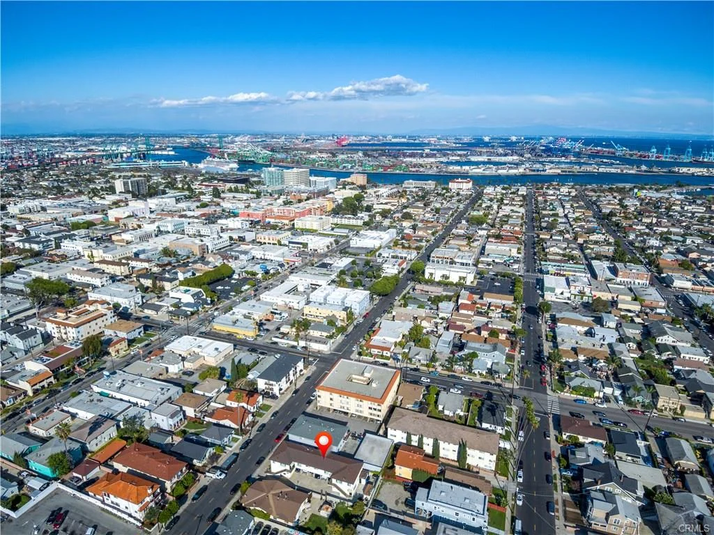 Aerial view of houses, streets, harbor, city, and location marker