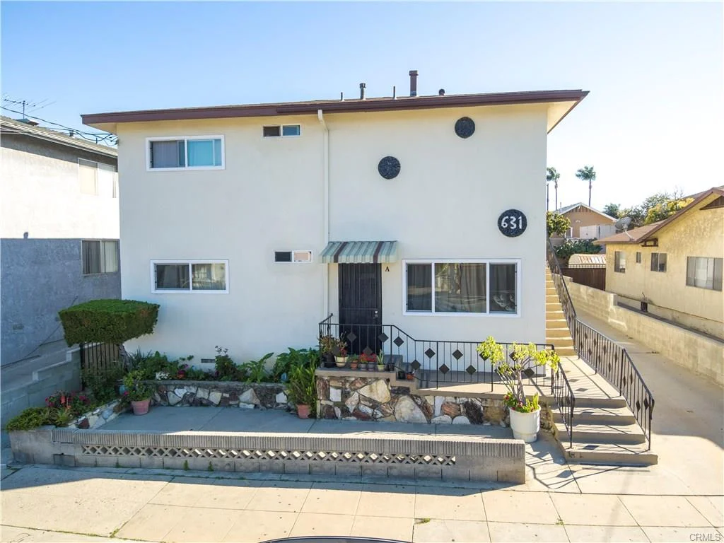 Two-story house California real estate with number 631, small garden, and stairs to entrance