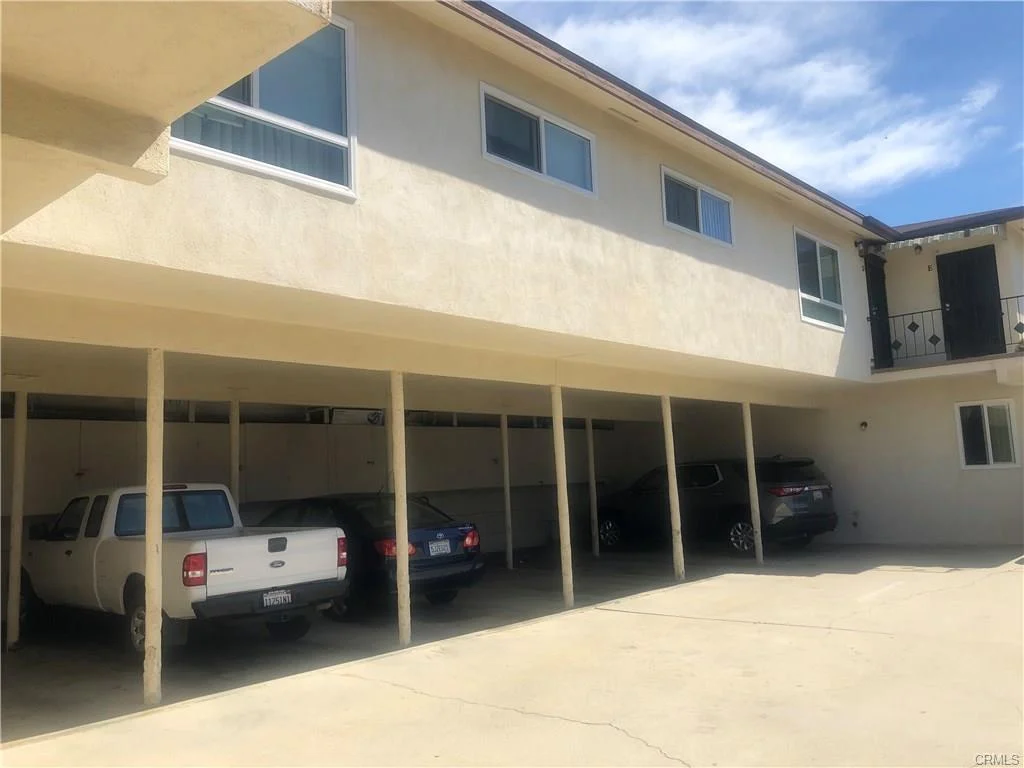 Building with flat roof and carport with parked cars