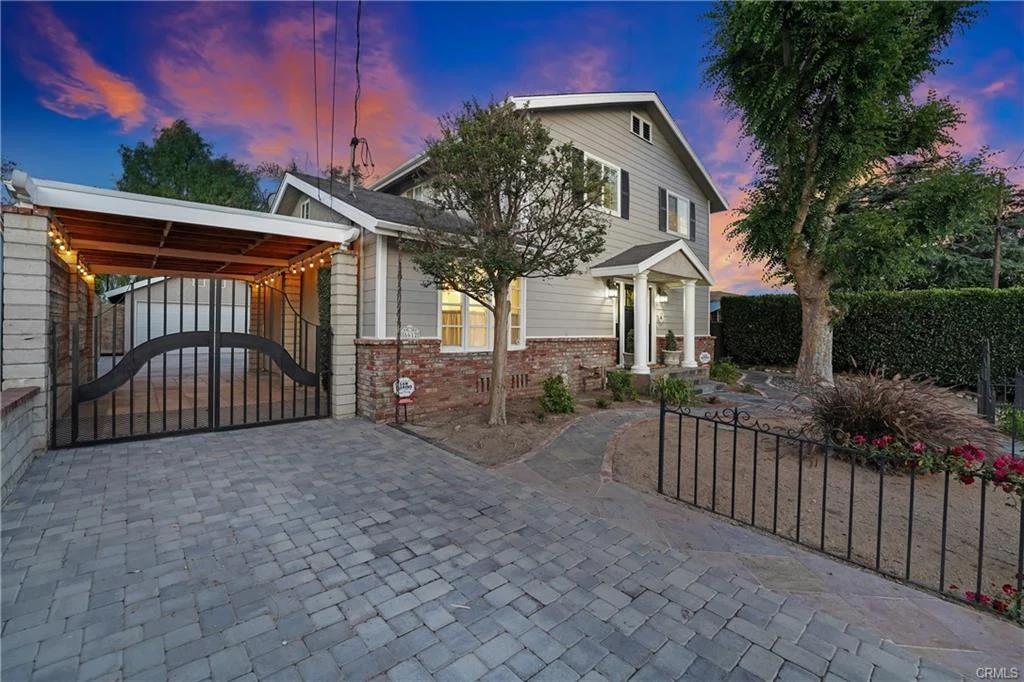 House California real estate with a stone driveway, a gate, and a front yard.