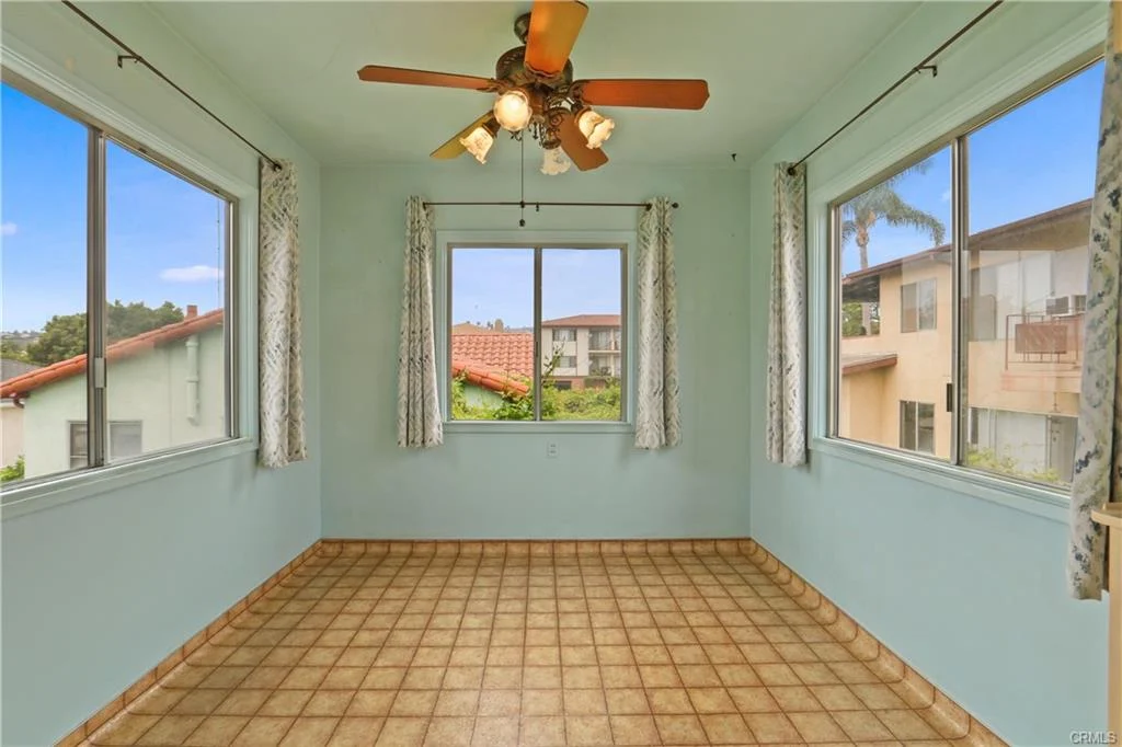 Room with tile floor and big windows.
