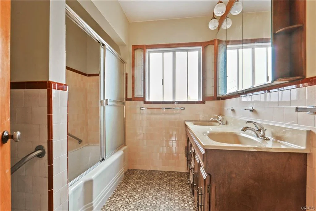 White bathroom with two sinks and a bathtub.