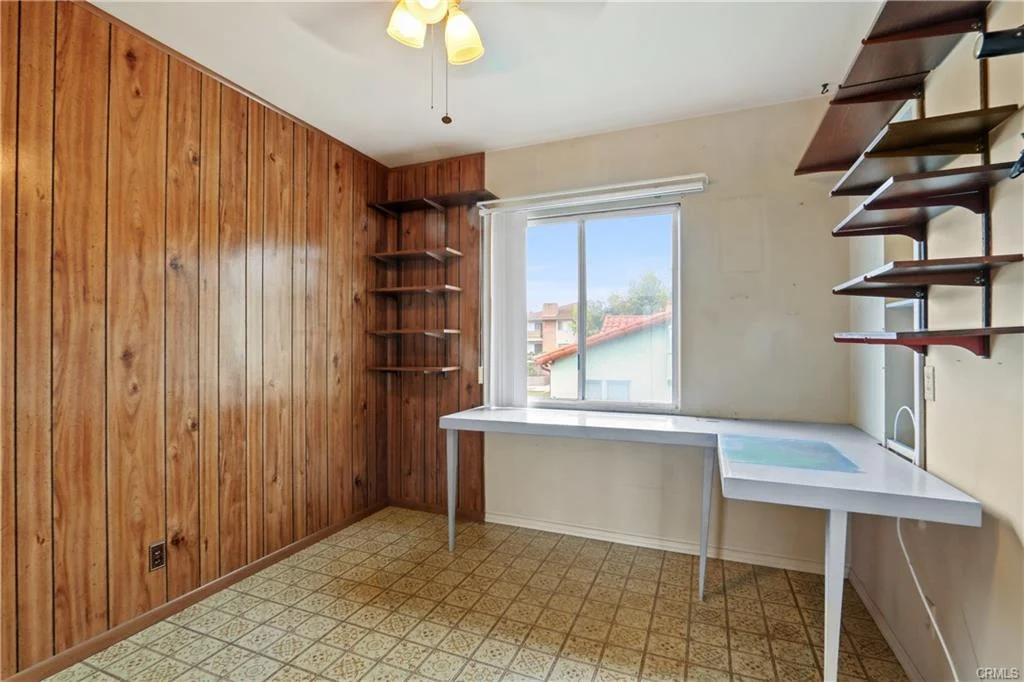 Room with wood walls and a desk.