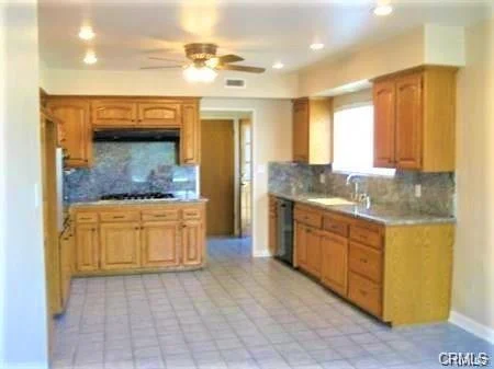 Kitchen with wooden cabinets, window, and tile floor