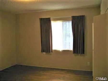Empty room with beige walls, window, and light-colored floor