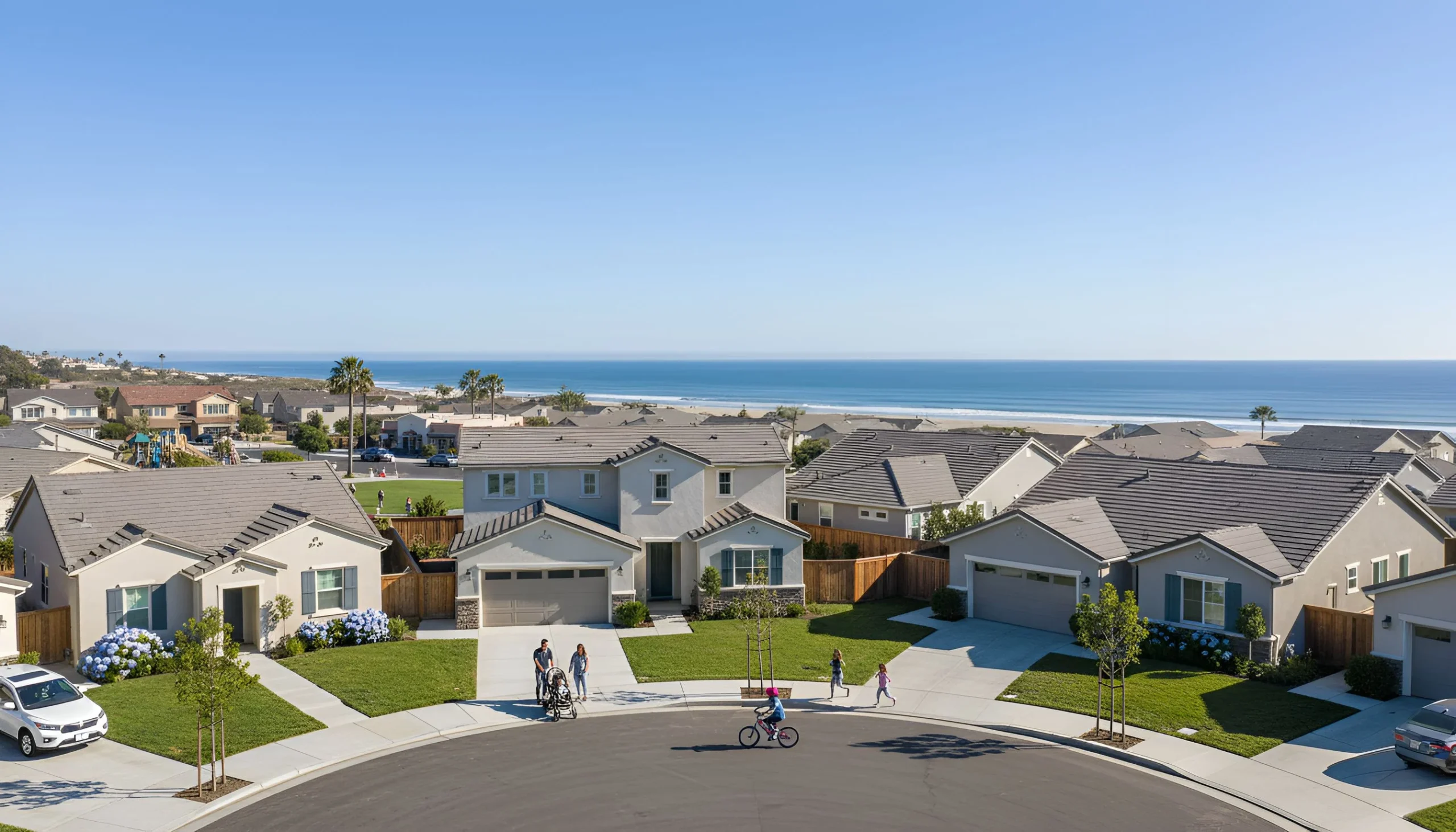 Houses California real estate in neighborhood with green lawns and beach nearby